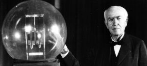 Thomas A. Edison seen here in 1929 holding a replica of his first lamp.